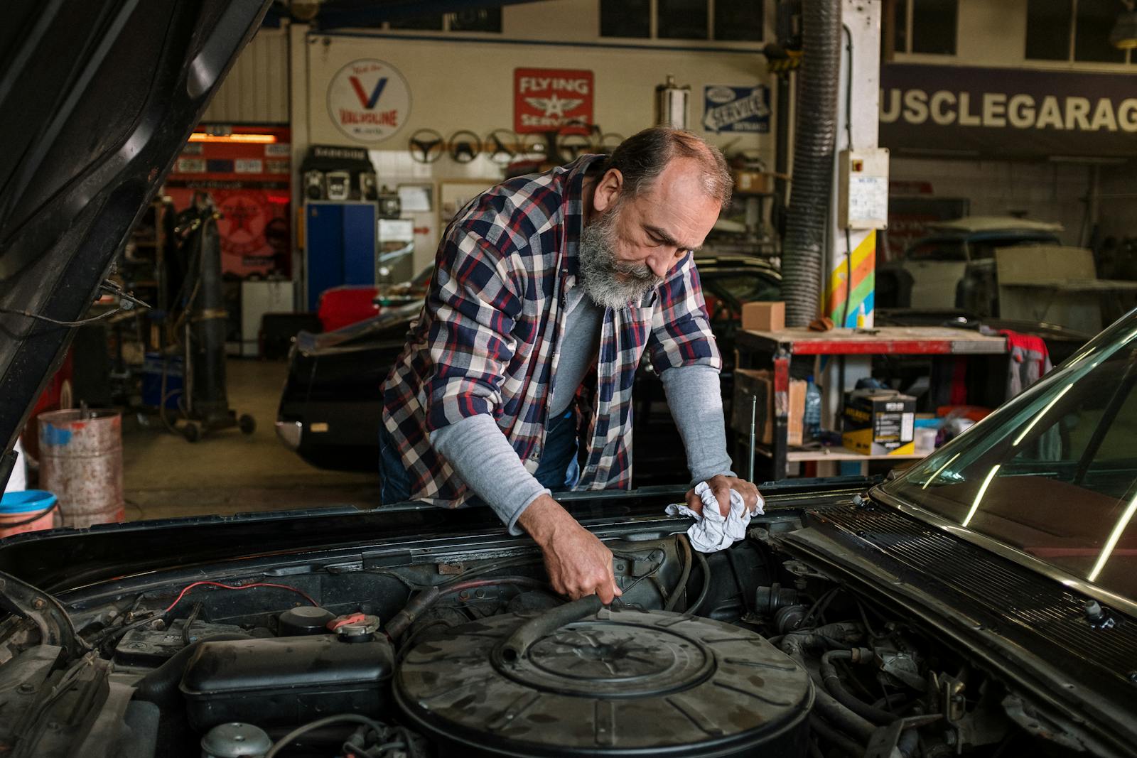 Bearded mechanic concentrating on engine work