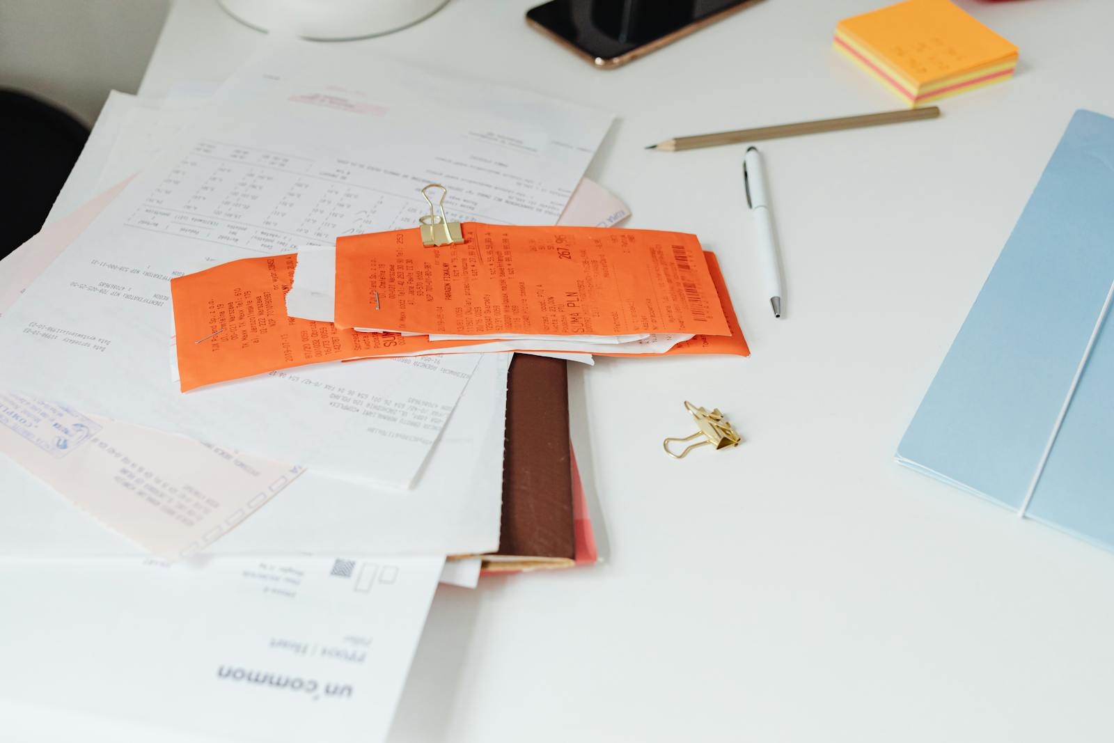 Desk covered with receipts, calculator, and stationery for accounting
