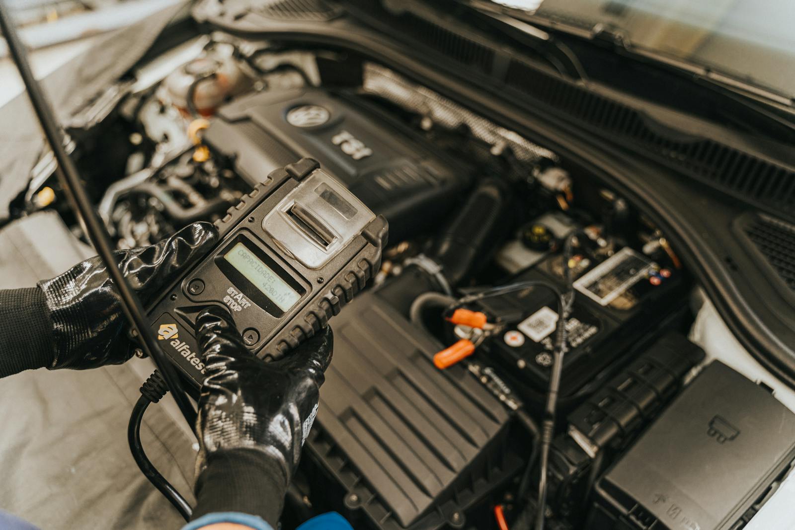 Mechanic using a diagnostic tool on a running engine