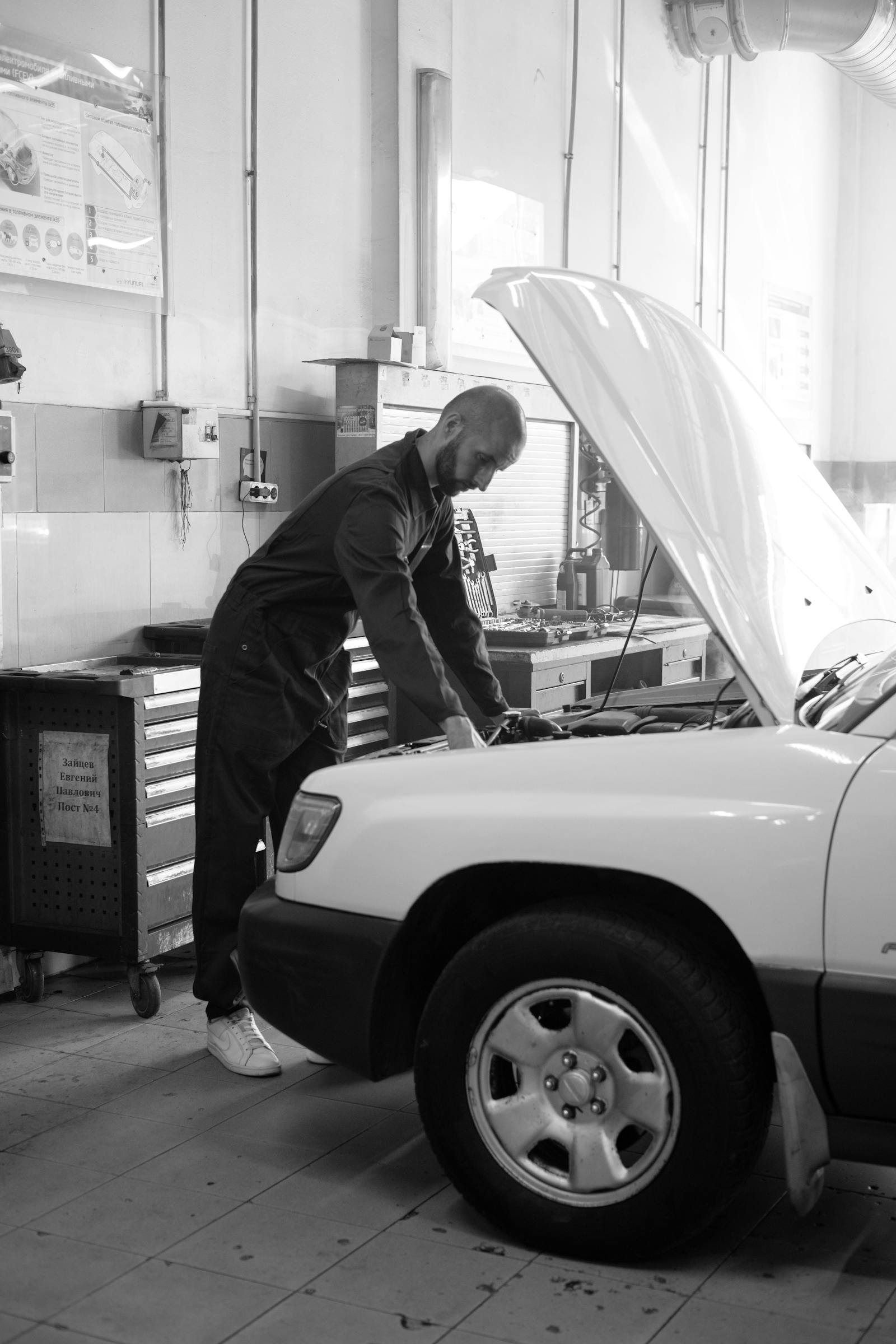 Mechanic inspecting an engine in a workshop bay