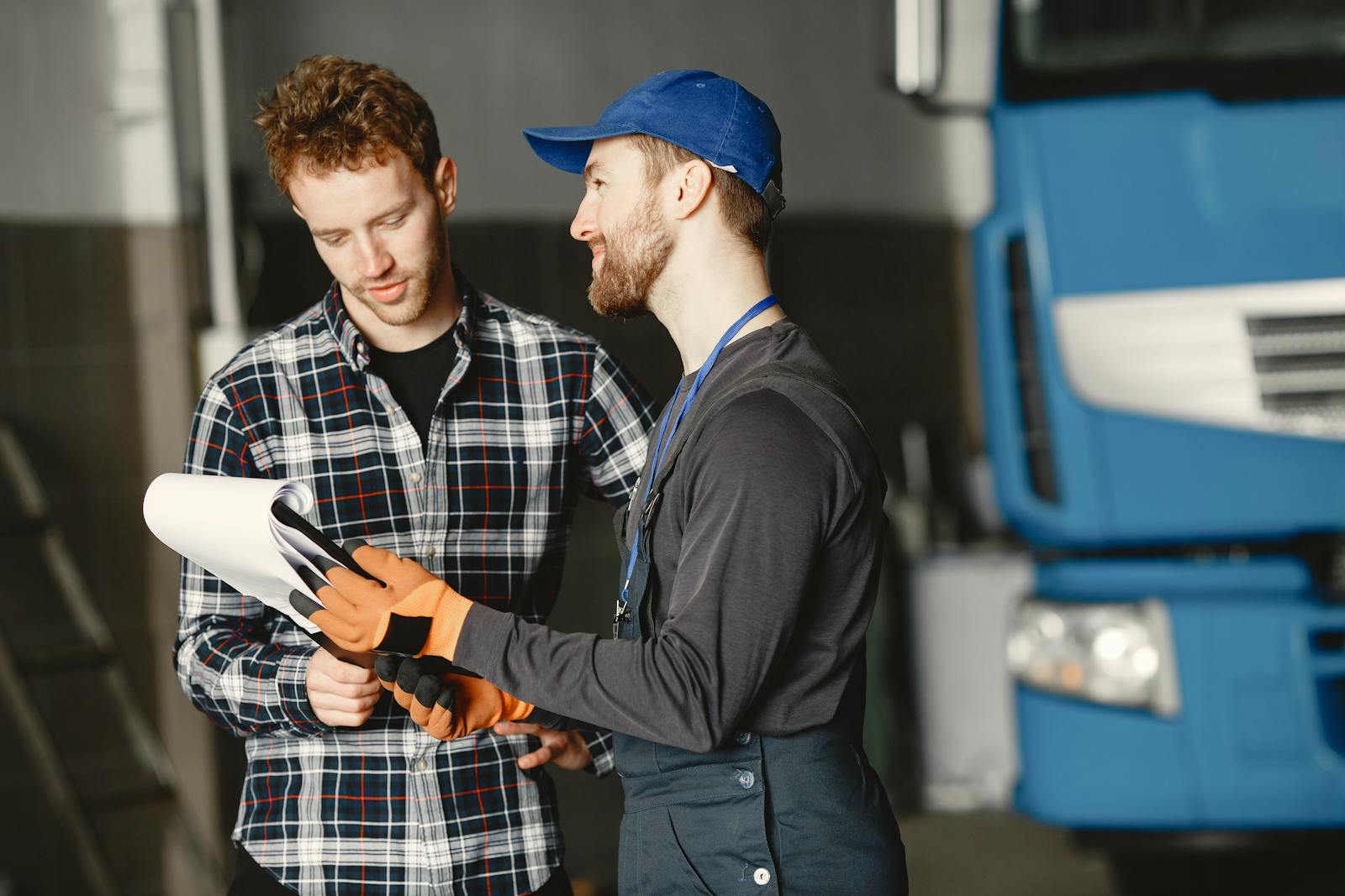 Mechanic consulting with a customer inside a garage bay