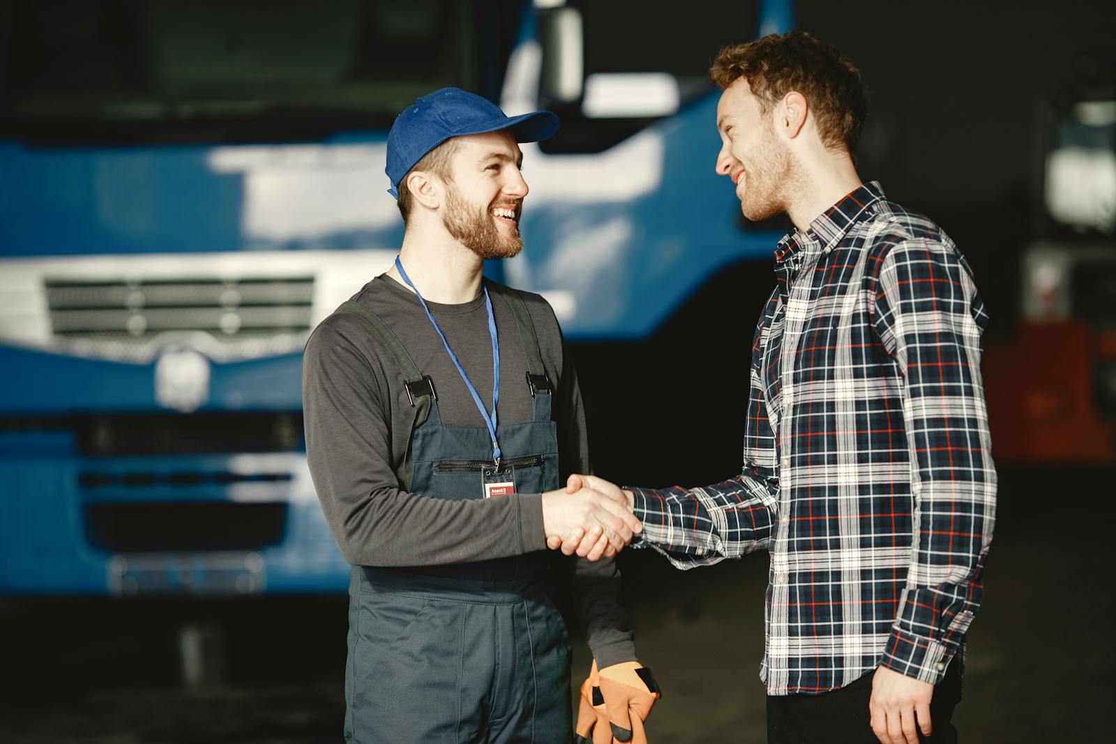 Mechanic shaking hands with a customer in front of a truck