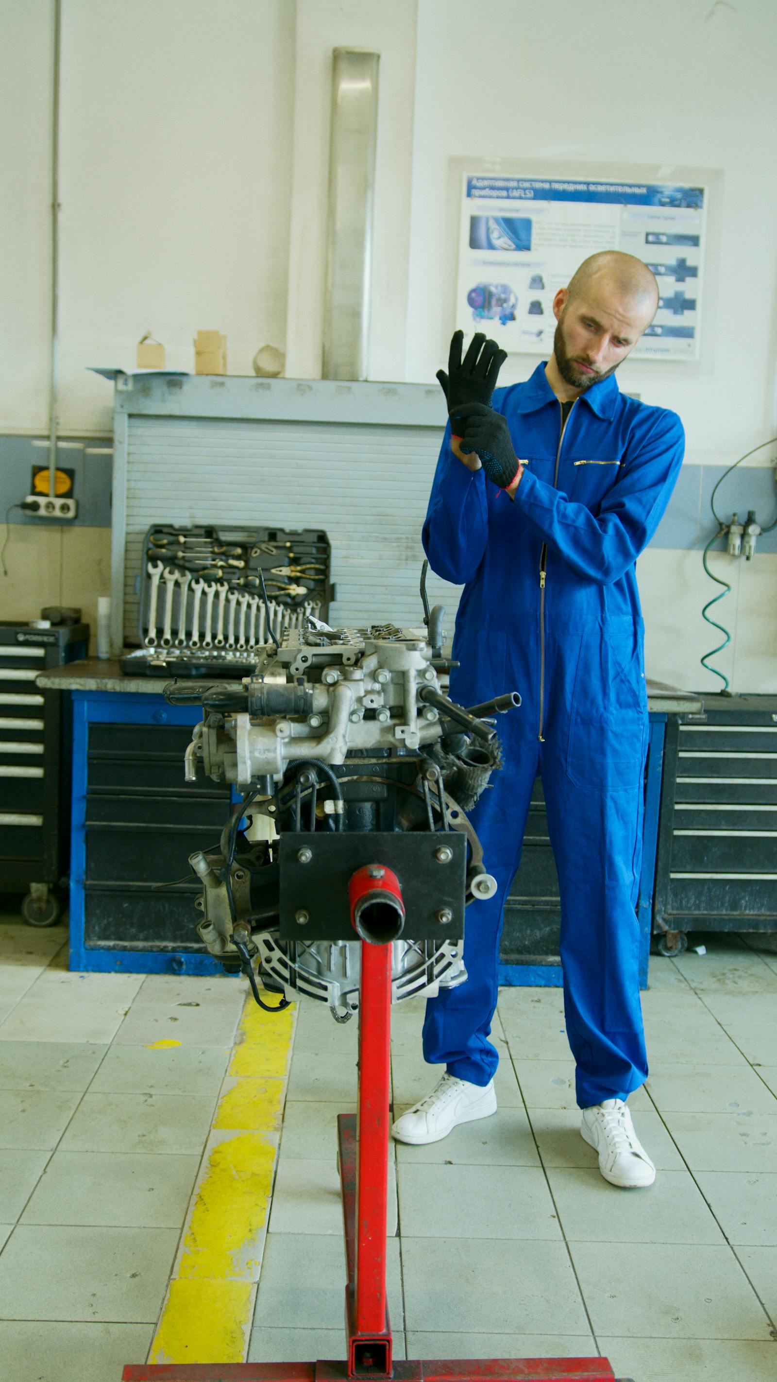 Mechanic wearing gloves working in an engine bay