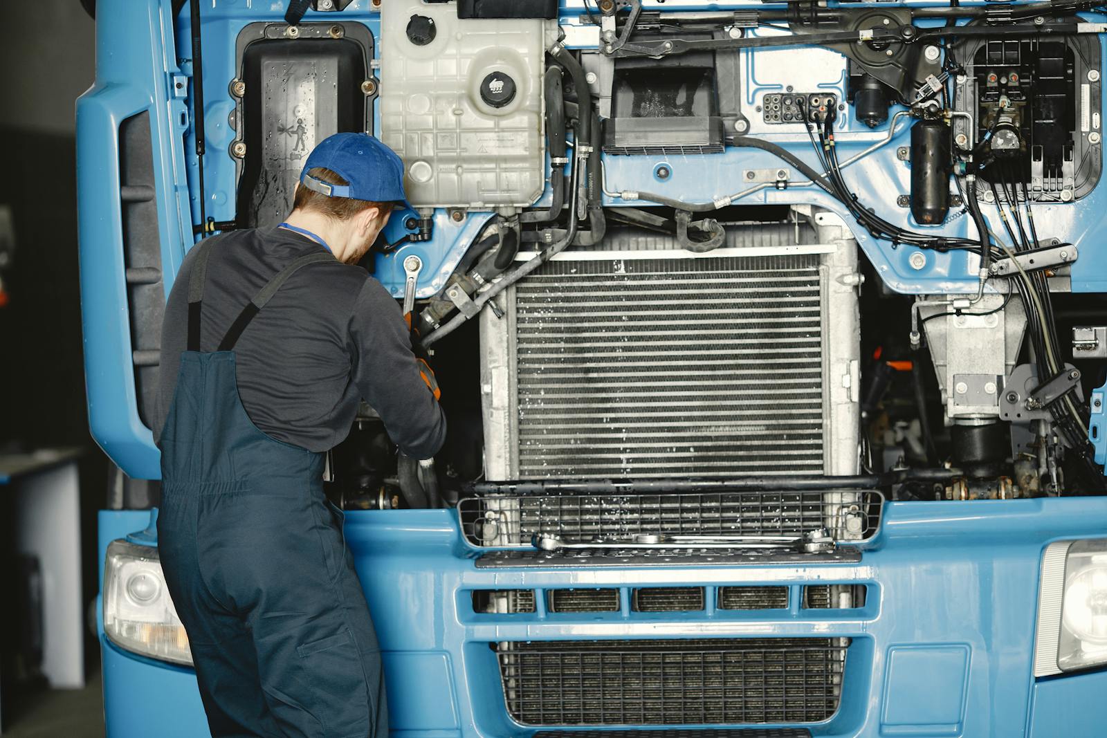 Mechanic servicing a large truck engine in a heavy-duty shop