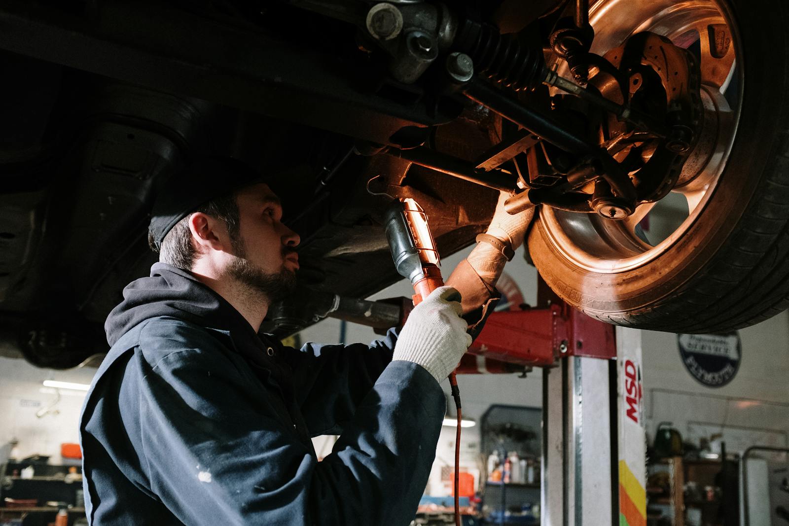 Mechanic working on a vehicle undercarriage
