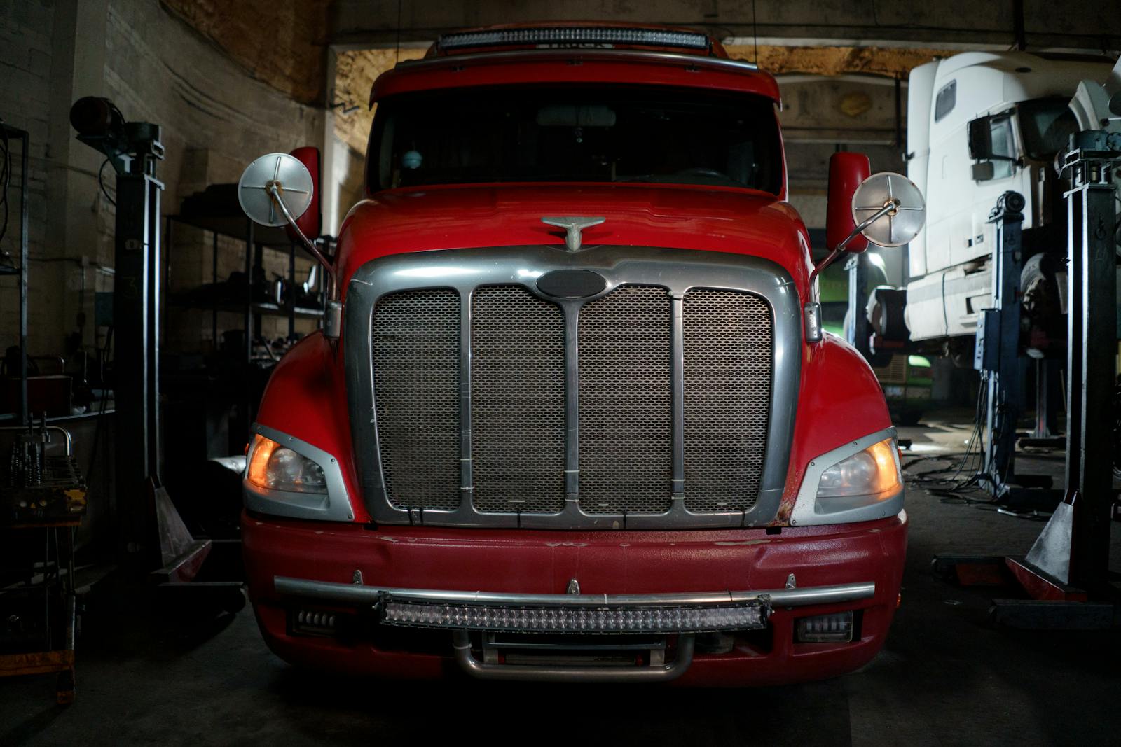 Red heavy-duty truck inside an industrial garage bay