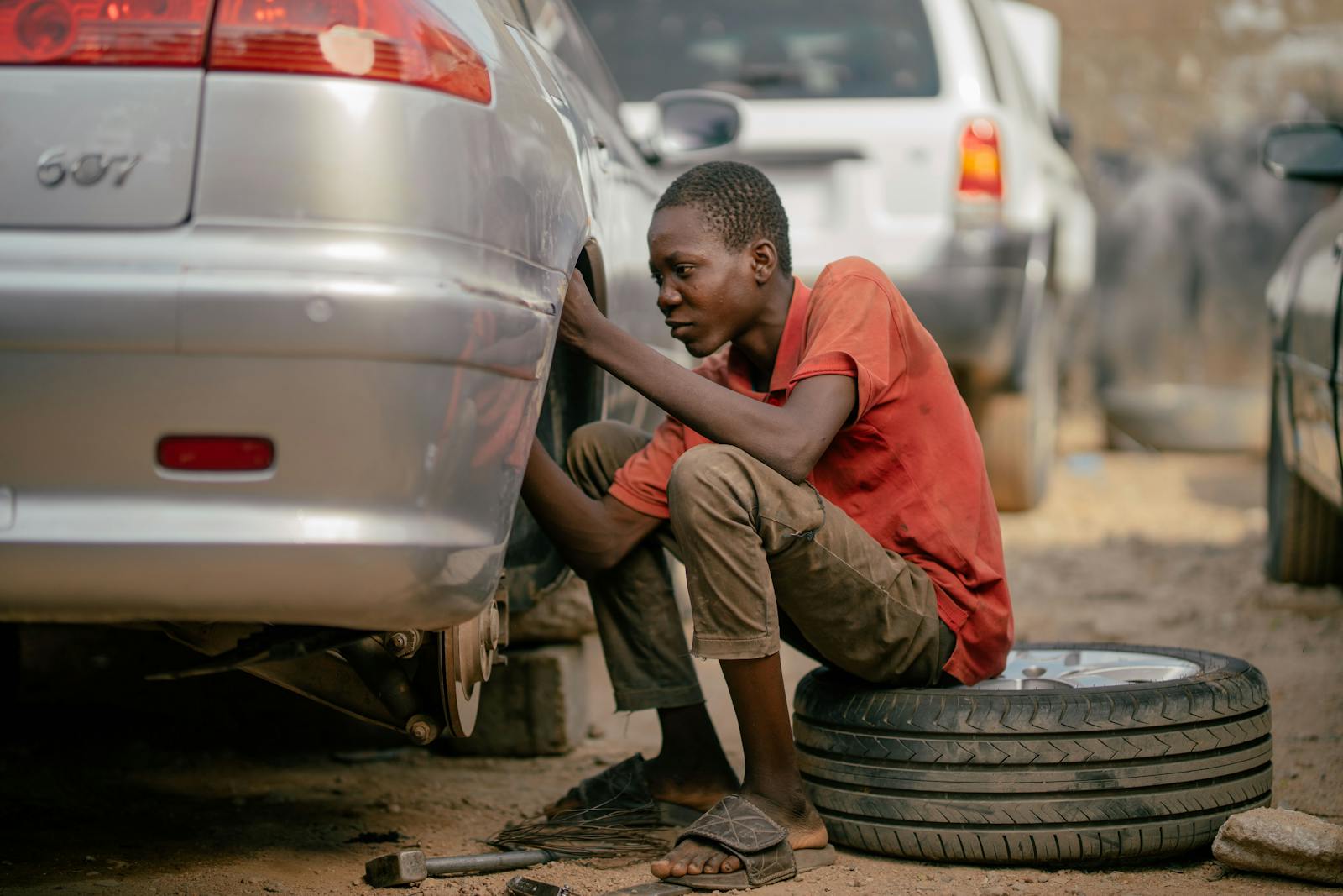 Outdoor tire change scene with tools laid out on the pavement