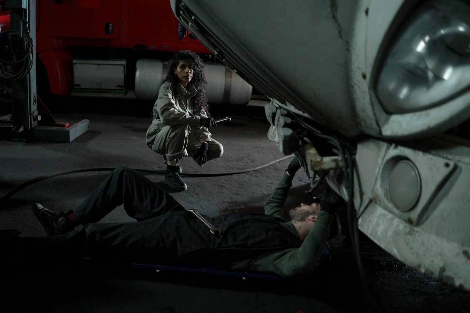 Two mechanics performing maintenance on a heavy-duty truck